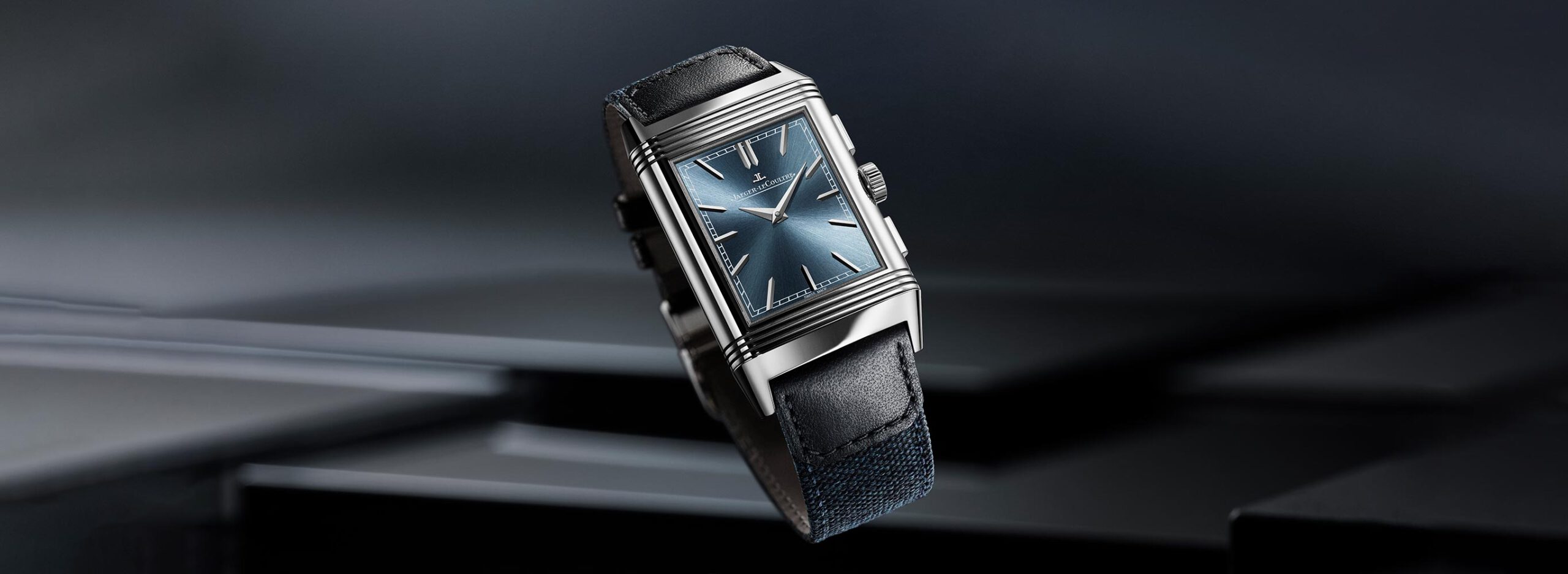 uhrenikonen-jaeger-lecoultre-reverso-intro-2732_1000 Uhrenklassiker Jaeger-LeCoultre Reverso schwebt vor einem grauen, strukturierten Hintergrund